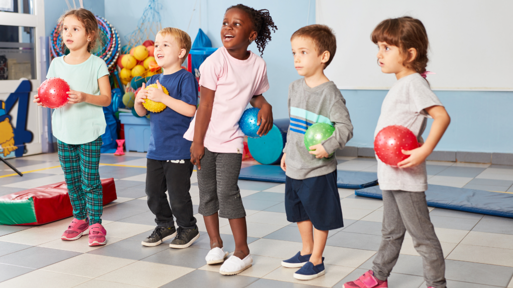 young children playing with balls in gym class