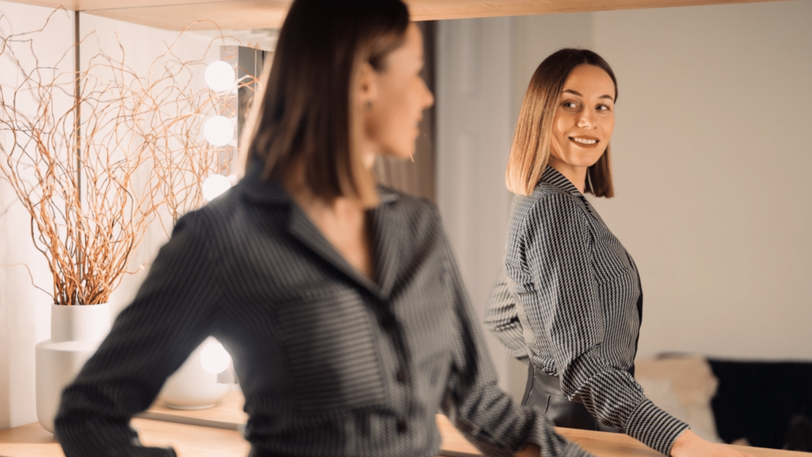 A confident woman standing in front of a mirror.