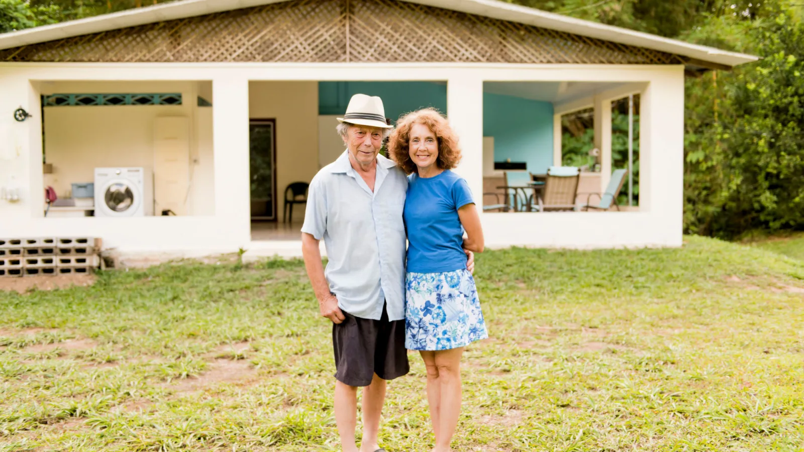 Senior couple hugs outside their house in Costa Rica