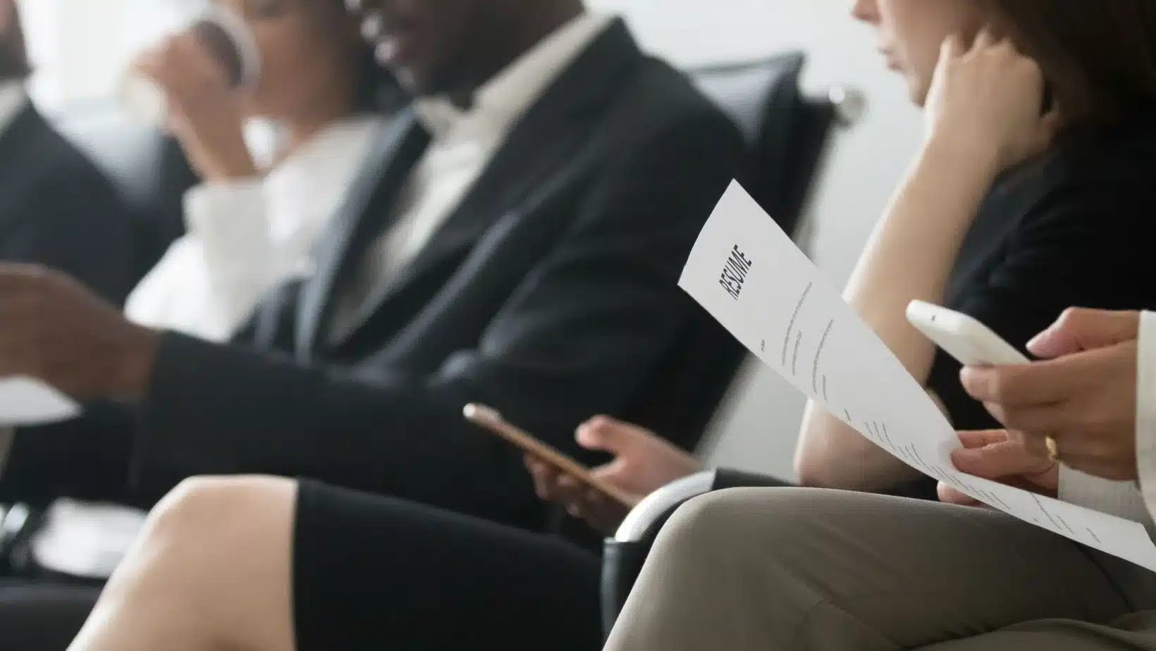 Job applicants wait for interviews with their resumes