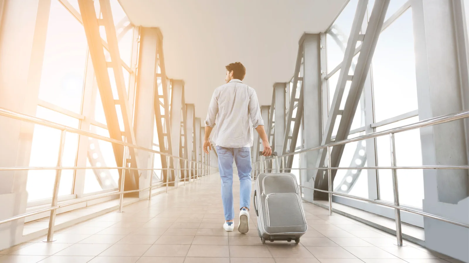 Person pulls their suitcase through an airport terminal