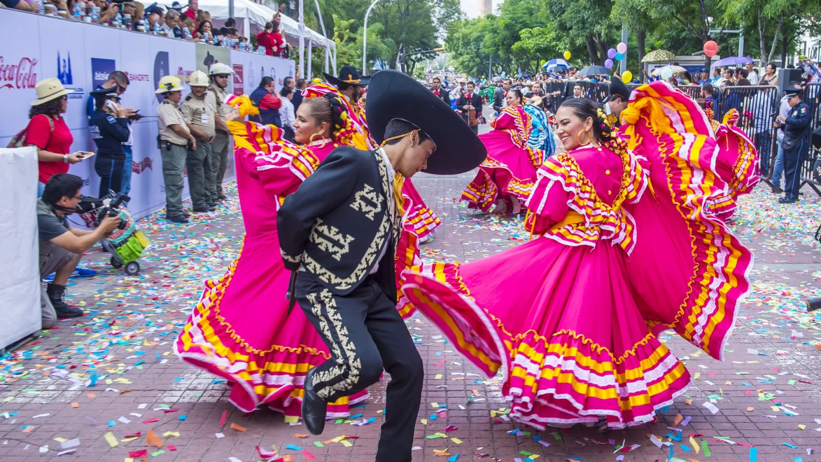 Mexican people dancing in colorful outfits.