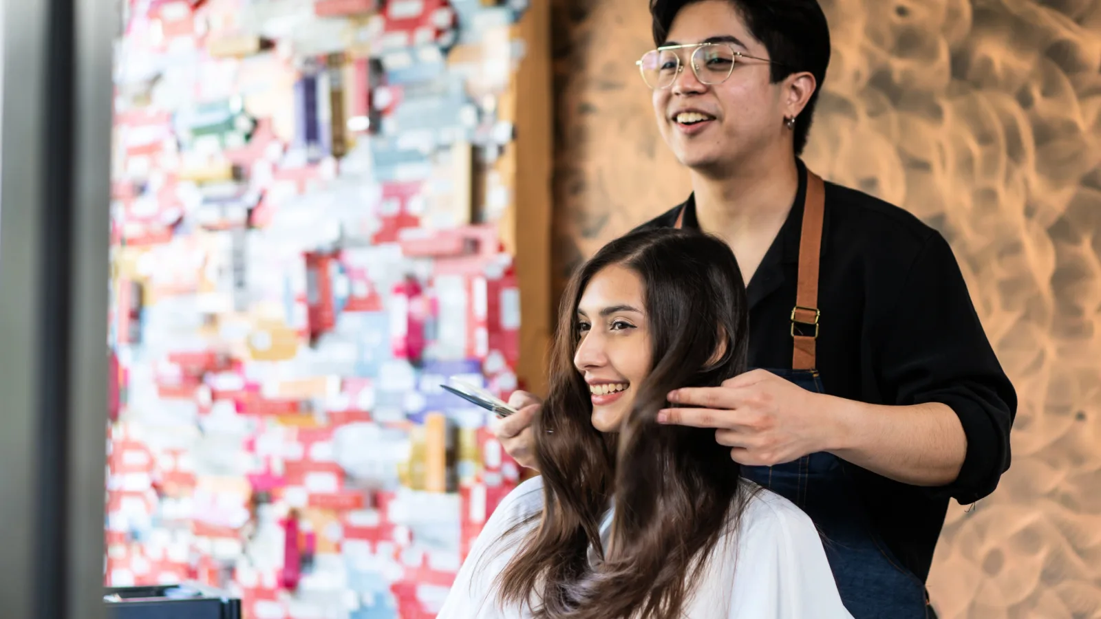 Hairstylist shows their client how the new cut looks