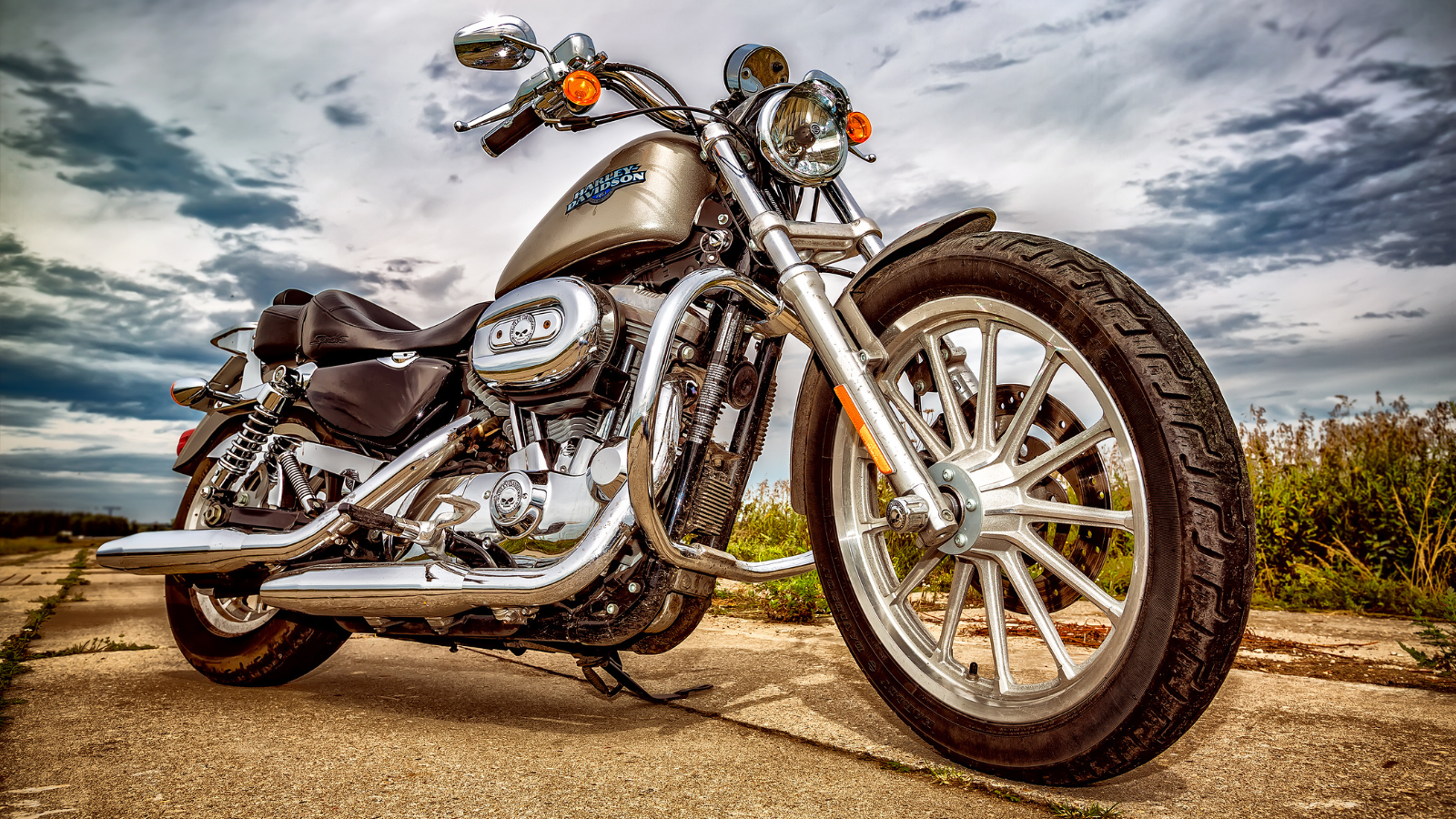 A motorcycle on a road against a cloudy sky.